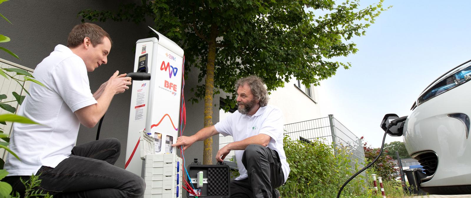 Zwei Männer arbeiten an der Ladesäule