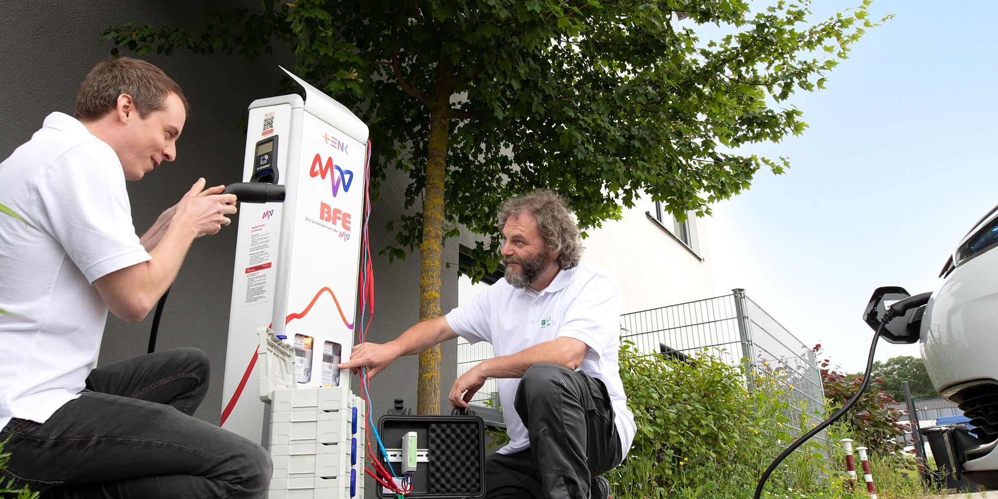 Zwei Männer arbeiten an der Ladesäule