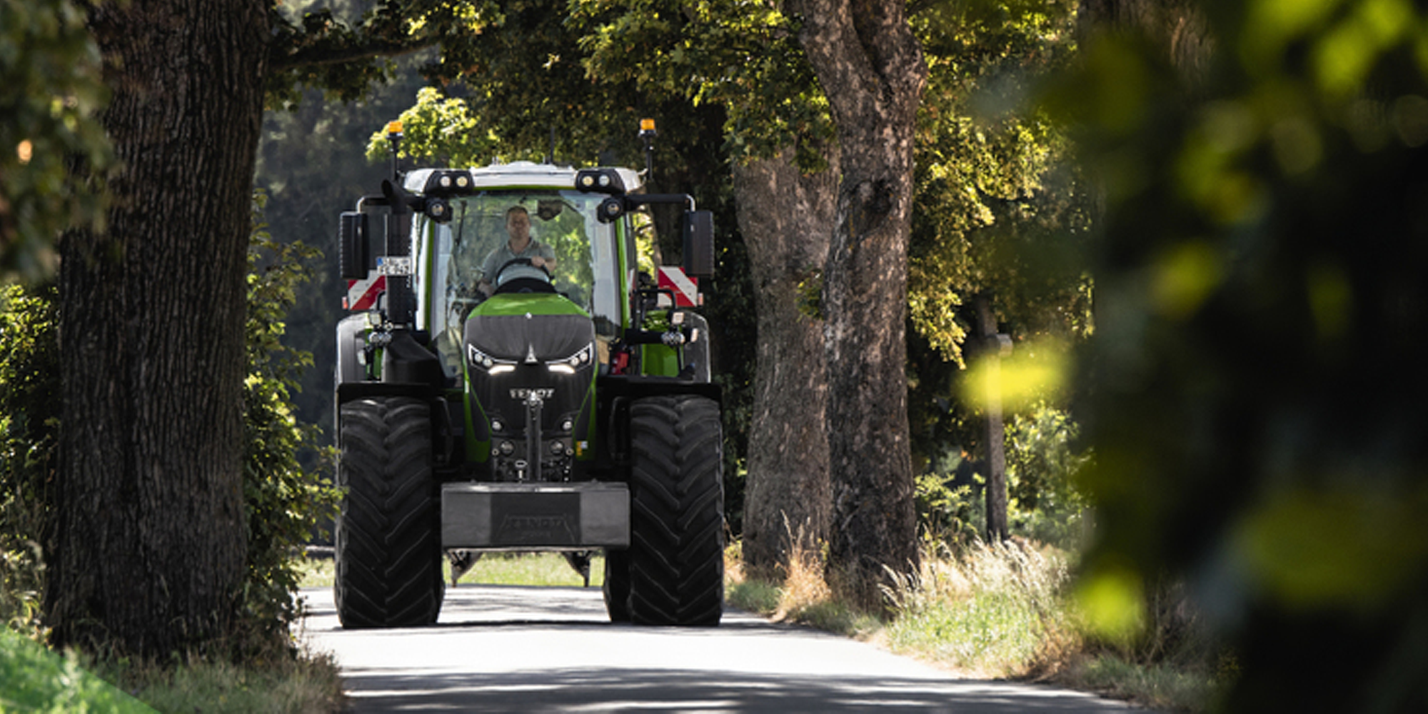 Traktor fährt auf ausgebautem Waldweg