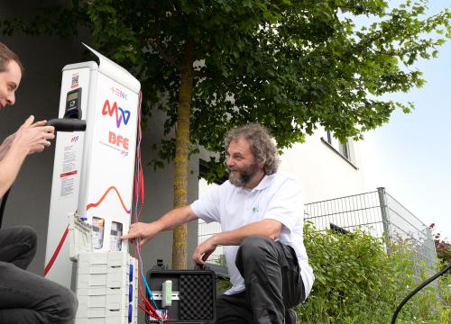 Zwei Männer arbeiten an der Ladesäule